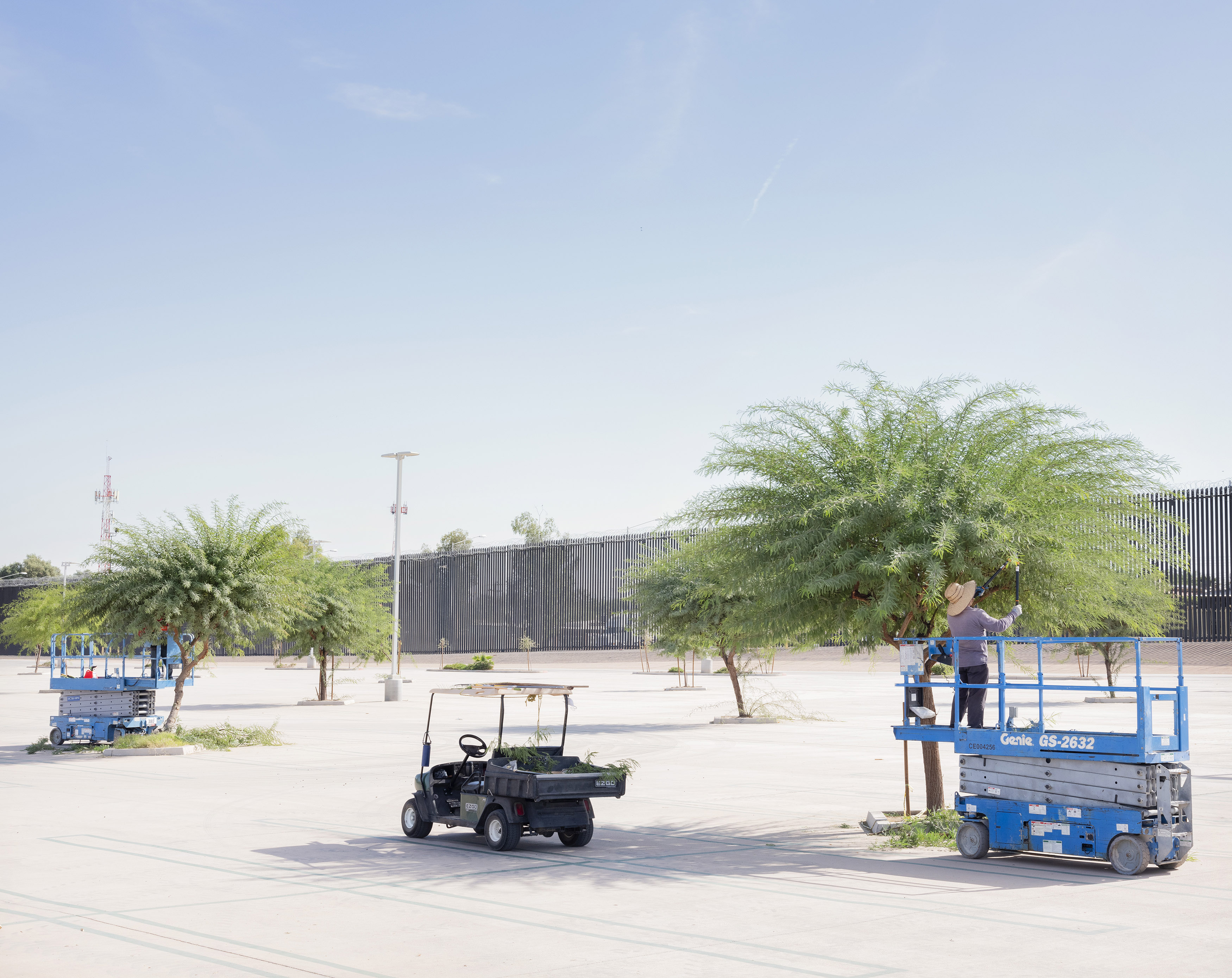 Rafal Milach's photo of a shopping mall parking lot by the Mexican-U.S. border wall.