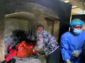 ​Malawi's minister of health places expired vaccines into an incinerator.