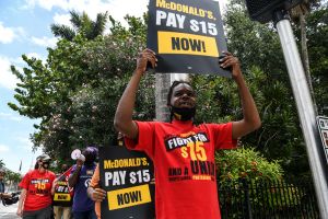 Employees of McDonald's march on the street as they protest for a raise in their minimum wage to $15 an hour, in Fort Lauderdale on May 19, 2021.