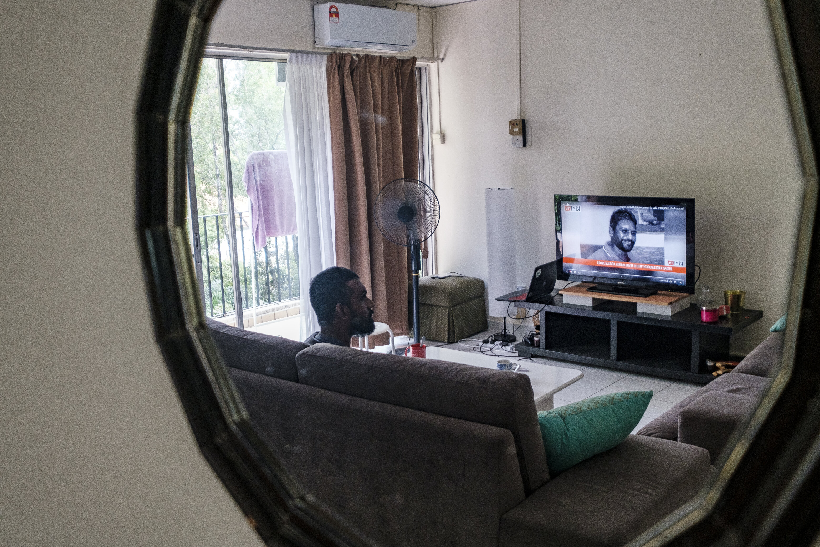 Pingalayen Kumar in his living room, watching media coverage of ongoing police brutality in the country​. Photo: Farhan Iqbal