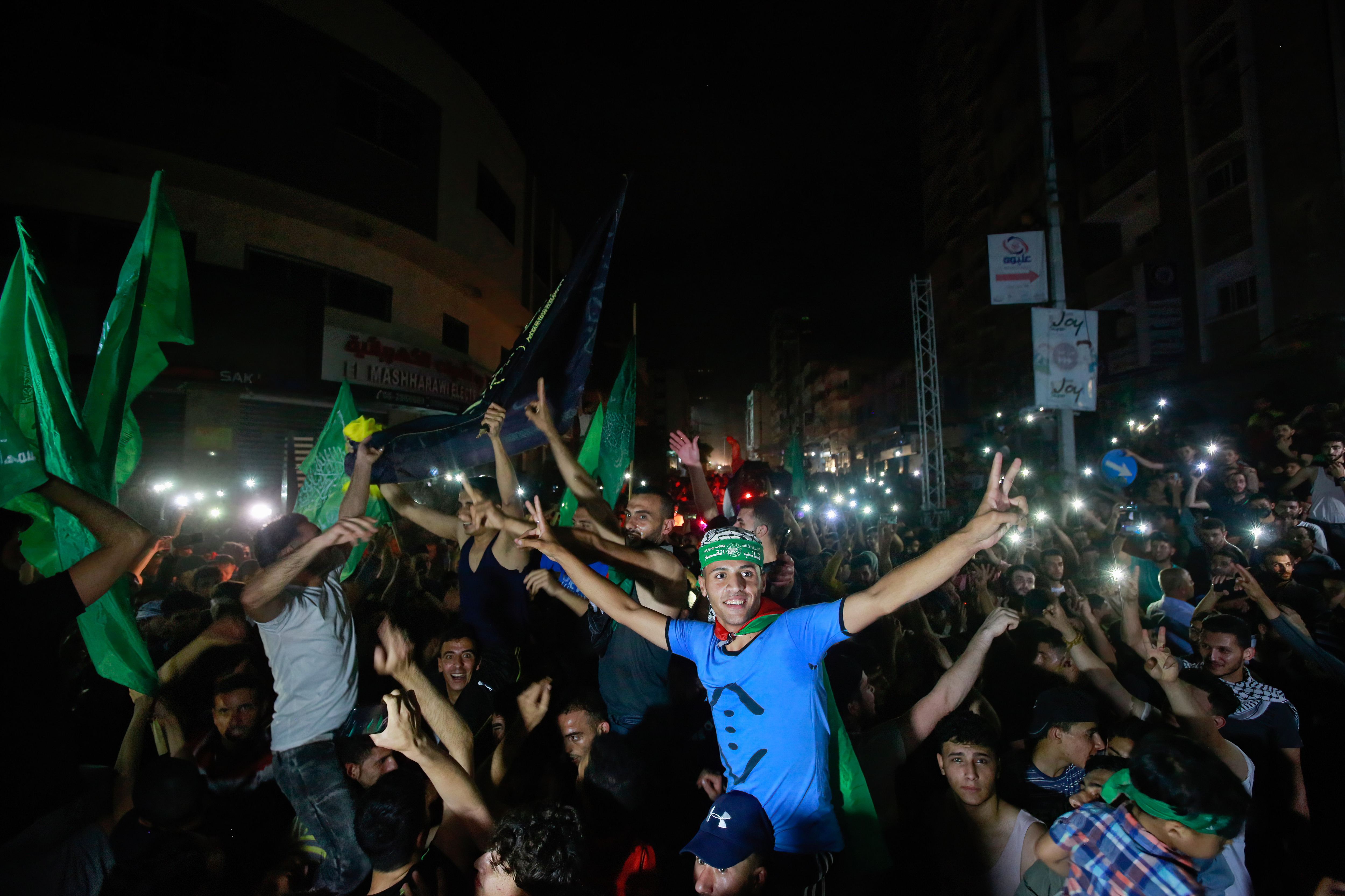 Palestinians celebrate on the street following a ceasefire brokered by Egypt between Israel and the ruling Islamist movement Hamas in Gaza City. A ceasefire between Israel and Hamas, the Islamist movement which controls the Gaza strip, came into force early on may 21, 2021 after 11 days of deadly fighting that pounded the Palestinian enclave and forced countless Israelis to seek shelter from rockets. (Photo by Ahmed Zakot/SOPA Images/LightRocket via Getty Images)