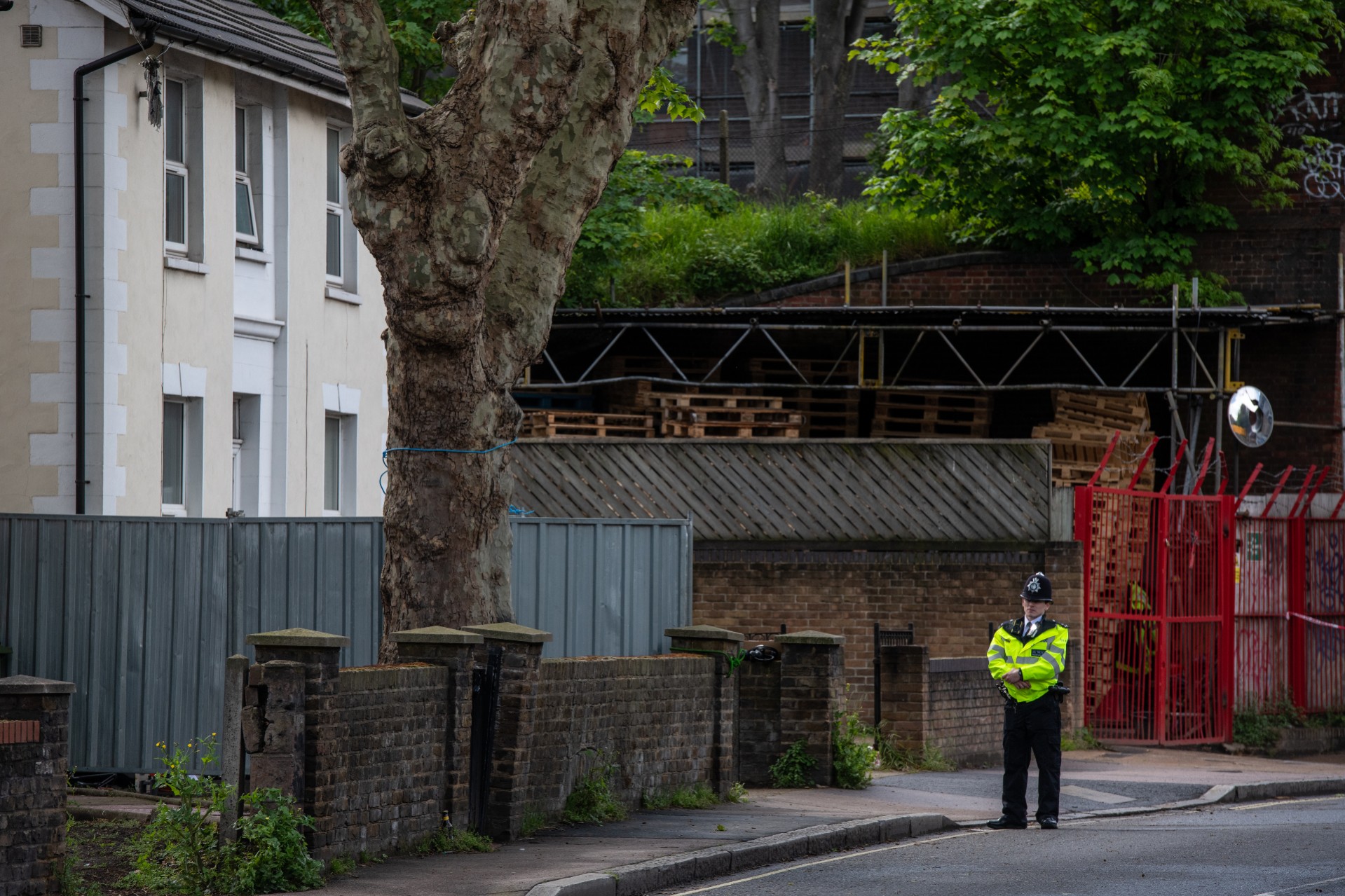 A police officer stands outside a house behind a cordon on Consort Road where they are investigating the shooting of Sasha Johnson. Photo: Chris J Ratcliffe/Getty Images