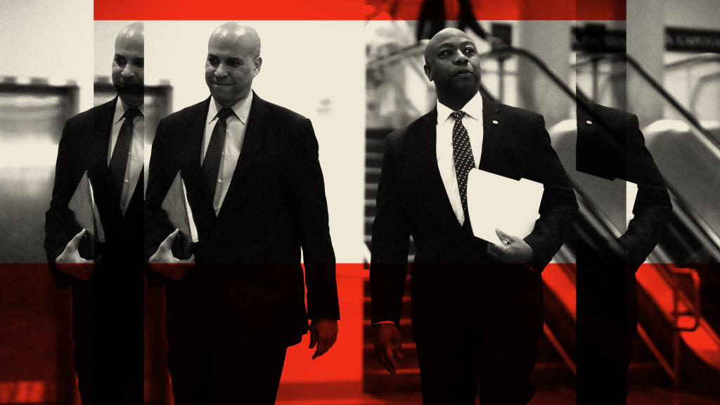 Sen. Cory Booker (D-NJ) (L) and Sen. Tim Scott (R-SC) walk to a briefing from administration officials on the coronavirus, on Capitol Hill February 25, 2020 in Washington, DC.