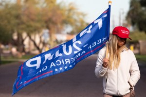 A protester in support of President Donald Trump holds a flag outside the State Capitol Executive Tower on December 14, 2020 in Phoenix, Arizona. (Photo by Courtney Pedroza for the Washington Post)