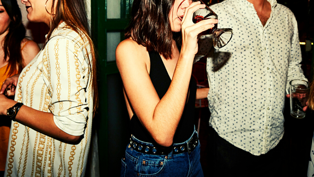 Woman enjoying a drink while on date with boyfriend in night club - stock photo