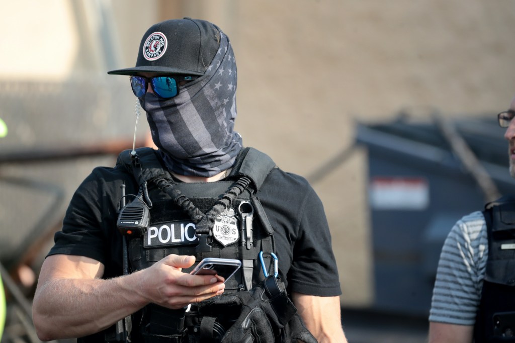 ATF agents investigate a fire started at an office furniture business during rioting on August 25, 2020 in Kenosha, Wisconsin.