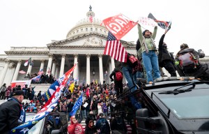 Trump supporters stand on the U.S. Capitol Police armored vehicle as others take over the steps of the Capitol on Wednesday, Jan. 6, 2021, as the Congress works to certify the electoral college votes. (Bill Clark/CQ-Roll Call, Inc via Getty Images)