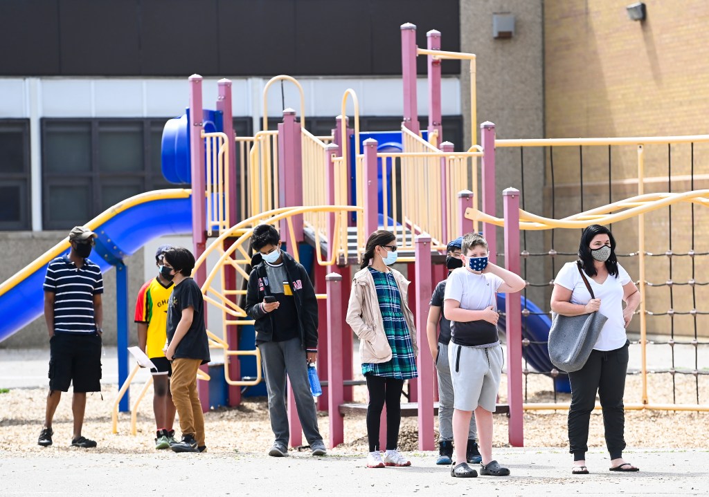 Families and youth aged 12 and older line up for a COVID-19 vaccine at Gordon A Brown Middle School in Toronto Wednesday May 19, 2021.