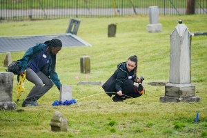 Workers measure between headstones at the site where excavation will take place at Oaklawn Cemetery in a search for victims of the Tulsa race massacre believed to be buried in a mass grave, Tuesday, June 1, 2021, in Tulsa, Okla.