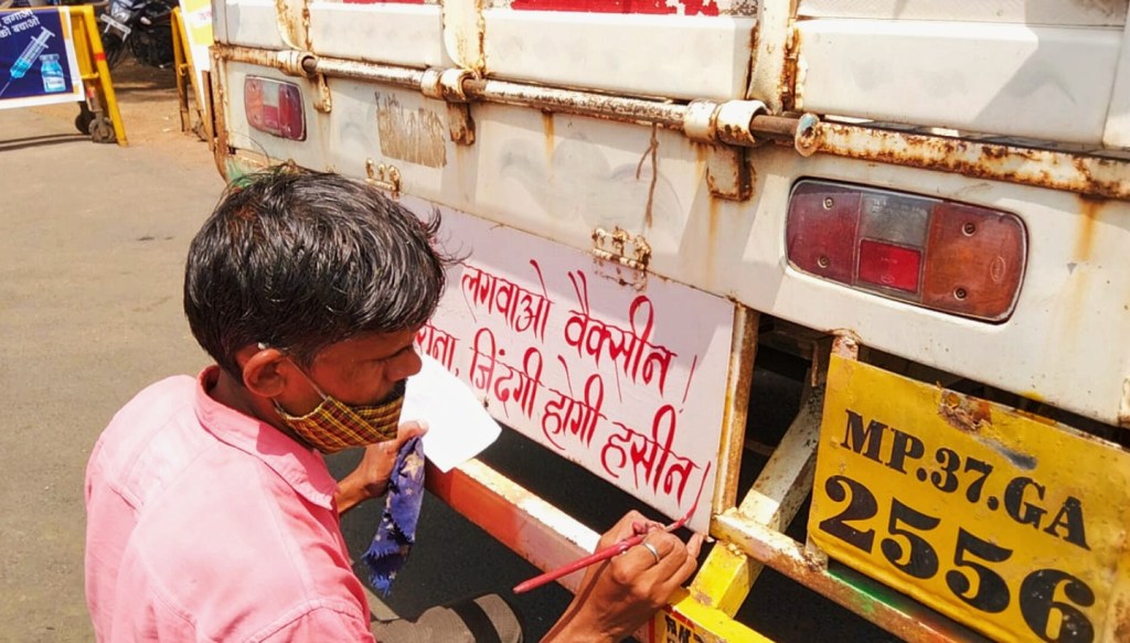 Pelukis menggambar slogan di pantat truk.