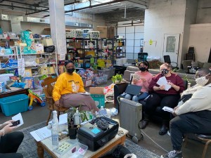 Mutual aid volunteers sit on chairs inside a warehouse in Richmond, Virginia con