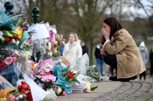 A woman reacts as she lays flowers in tribute to Sarah Everard at the bandstand on Clapham Common on March 13, 2021 in London, United Kingdom.