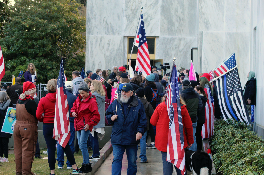 Pro-Trump and anti-mask demonstrators hold a rally outside the Oregon State Capitol as legislators meet for an emergency session in Salem, Ore on Dec. 21, 2020​ before breaking into the building.