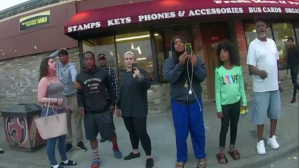 This May 25, 2020 file image from a police body camera shows bystanders including Darnella Frazier, third from right filming, as former Minneapolis police officer Derek Chauvin was recorded pressing his knee on George Floyd.