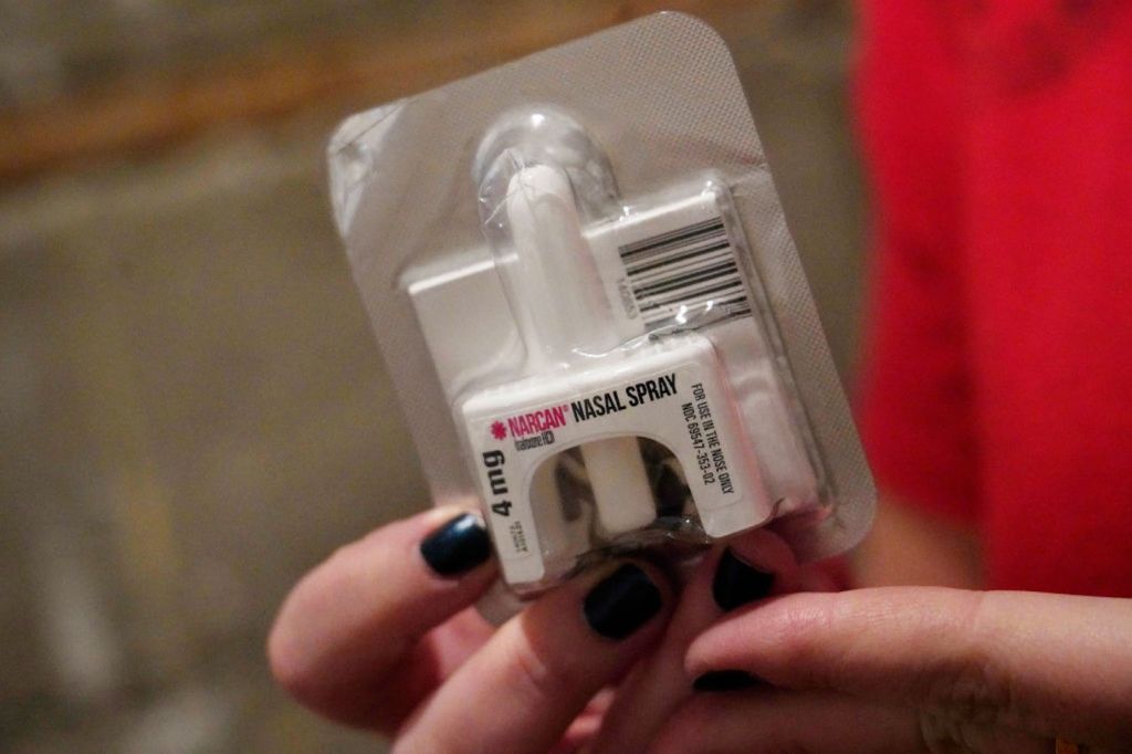 A person holds a dose of Narcan naloxone nasal spray