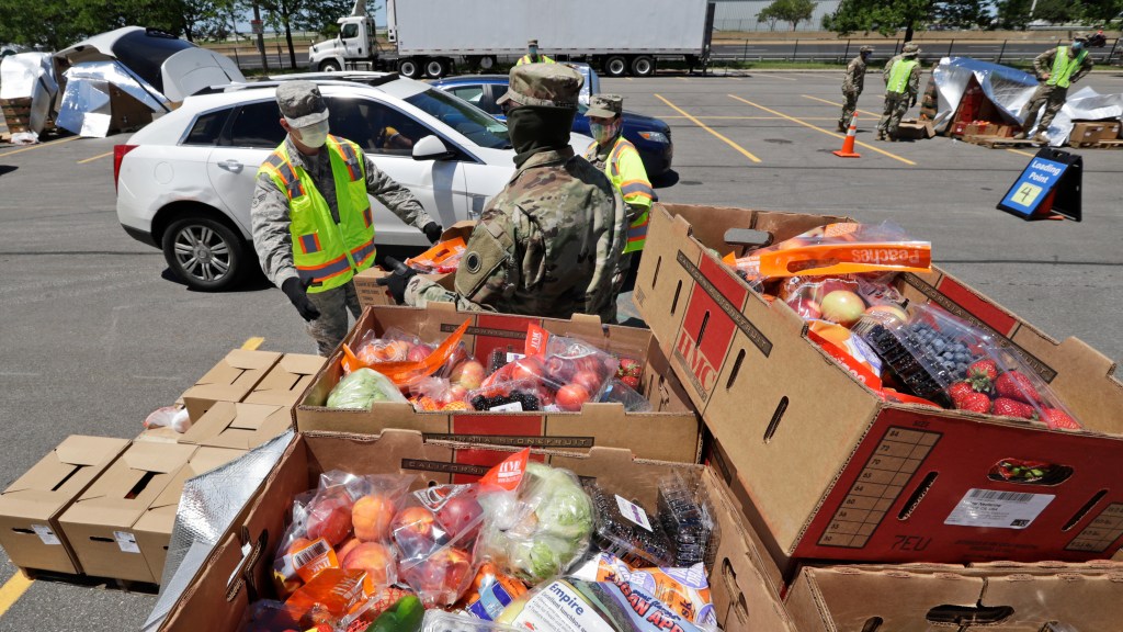 Members of the Ohio National Guard help load cars with food at the Greater Cleveland Food Bank food distribution, Thursday, June 11, 2020, in Cleveland.