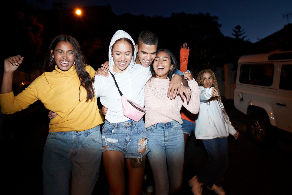 Happy young friends dancing at night - stock photo