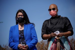 Reps. Rashida Tlaib and Ayanna Pressley stand outside wearing masks.