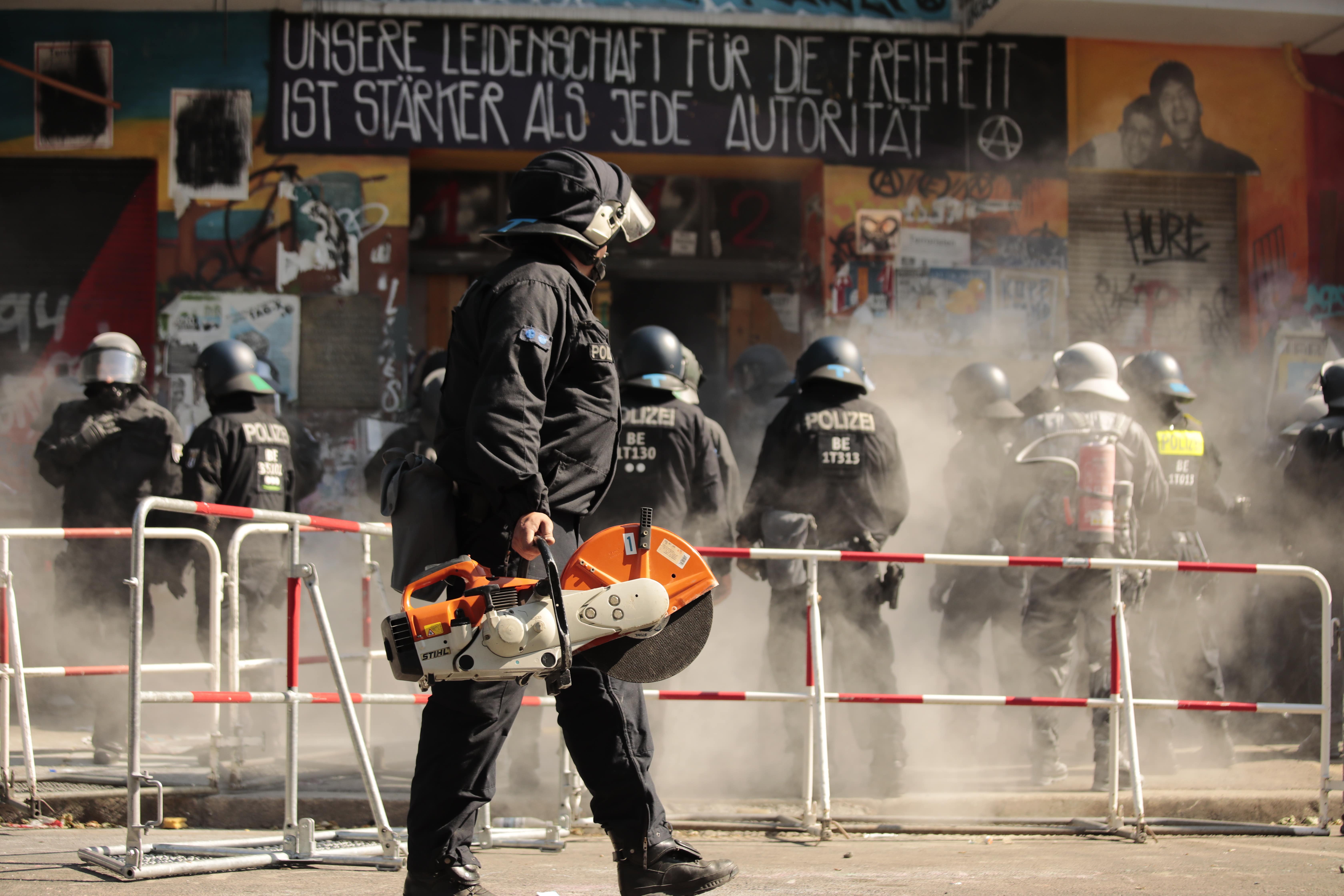 Police officers open the door to the house Rigaer 94 on Rigaer Straße in Berlin-Friedrichshain. Photo: Carsten Koall/picture alliance via Getty Images