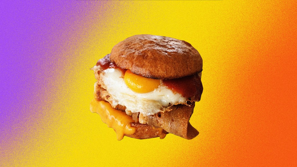 a breakfast sandwich featuring vegan bacon and a vegan fried egg from crux in adelaide australia; the sandwich is in front of a colorful, grainy gradient