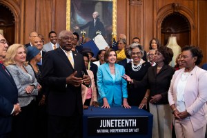 Speaker of the House Nancy Pelosi, D-Calif., center, House Majority Whip Jim Clyburn, D-S.C., and other members attend a bill enrollment ceremony for the Juneteenth National Independence Day Act in the Capitol on Thursday, June 17, 2021. (Tom Williams/CQ-