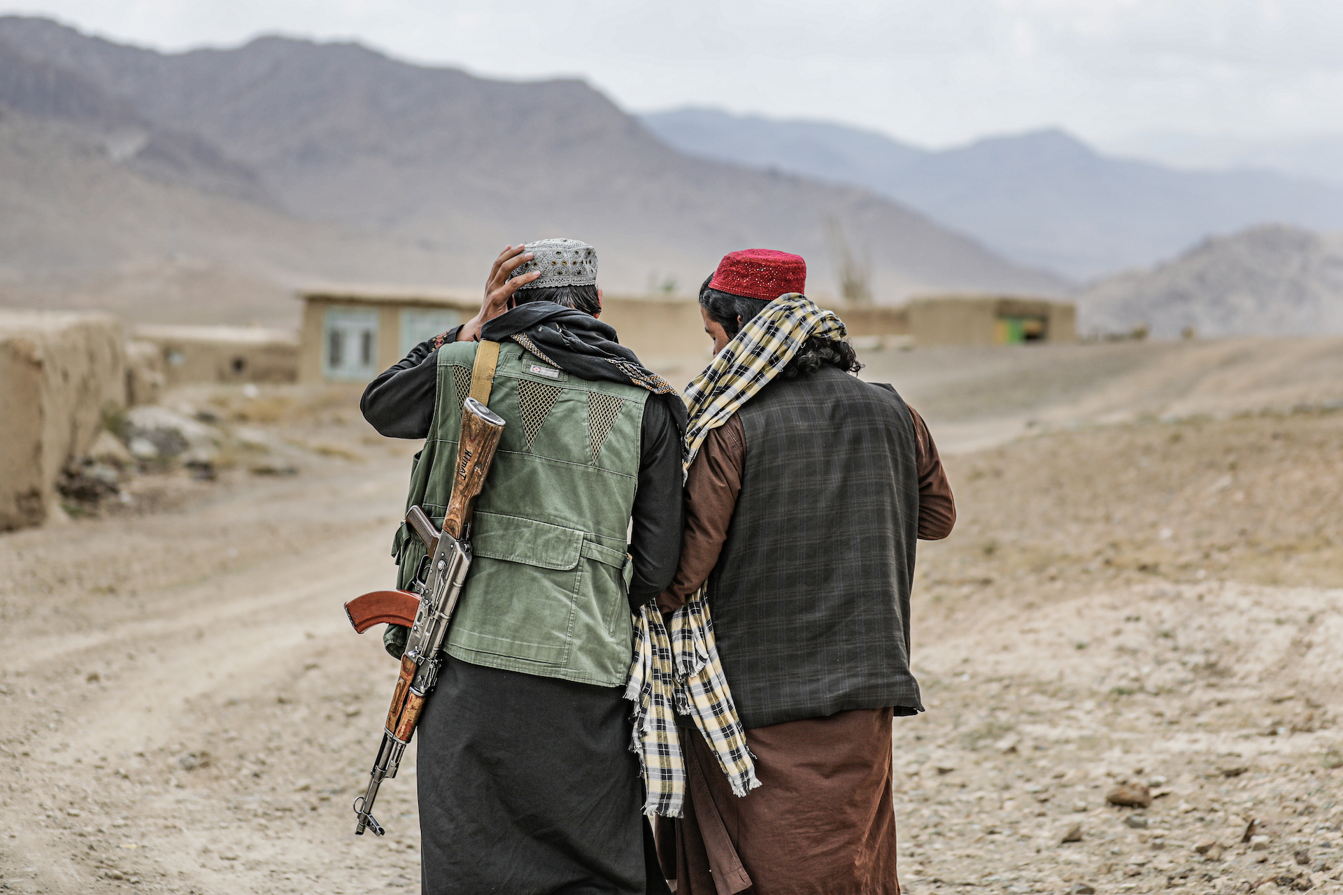 Taliban fighters hold hands while walking through the Band-e-chak district of Wardak Province, Afghanistan.