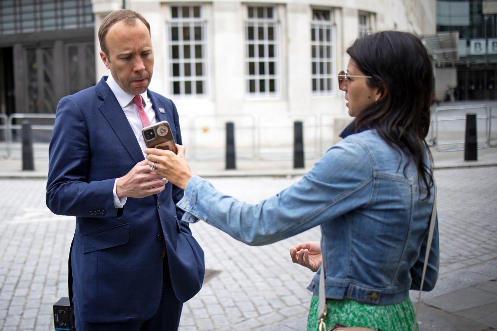 Britain's Health Secretary Matt Hancock (L), looks at the phone of his aide Gina Coladangelo as they leave the BBC in central London on the 6th of June, 2021, after appearing on the BBC political programme The Andrew Marr Show. Photo: TOLGA AKMEN/AFP via