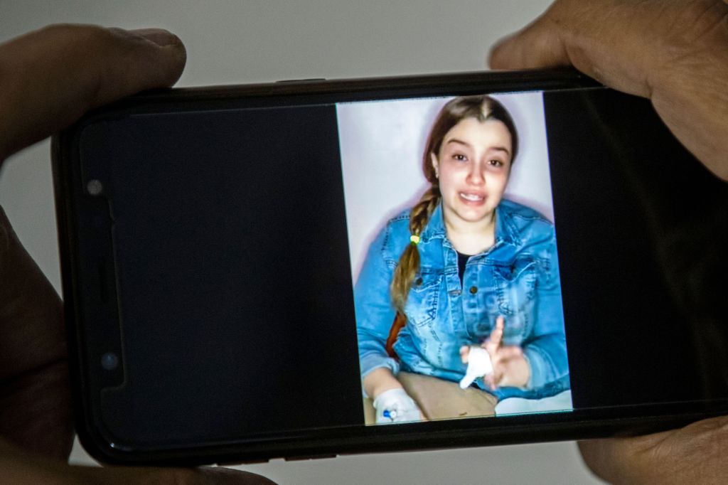 ​A man watches a video posted by Haneem Hossam, pleading for authorities to drop charges against her. Photo: HALED DESOUKI/AFP via Getty Images​