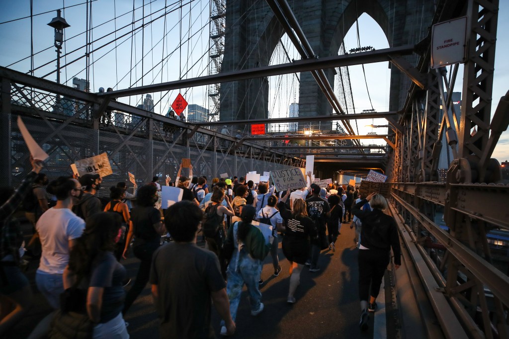 Protesters march across the Brooklyn Bridge on the one year anniversary of the murder of George Floyd.