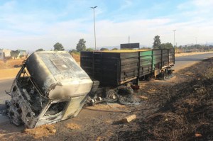 A burnt truck is seen on the side of the road in Manzini, Eswatini.