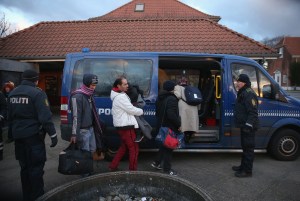 Danish police escort a family from Syria seeking asylum in Denmark