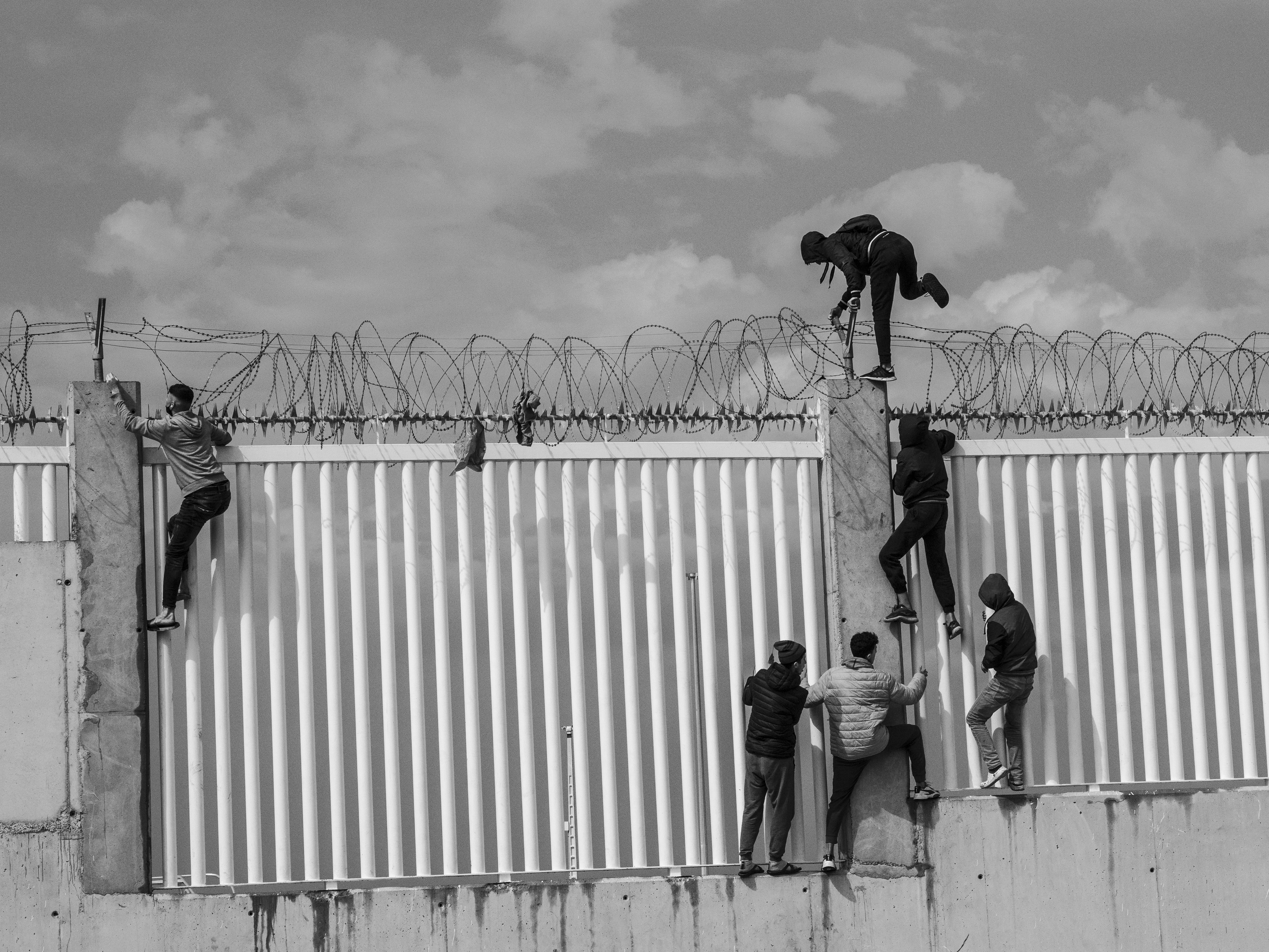 Hervé Lequeux, Ceuta – Giovanissimi migranti scavalcano un muro a Ceuta