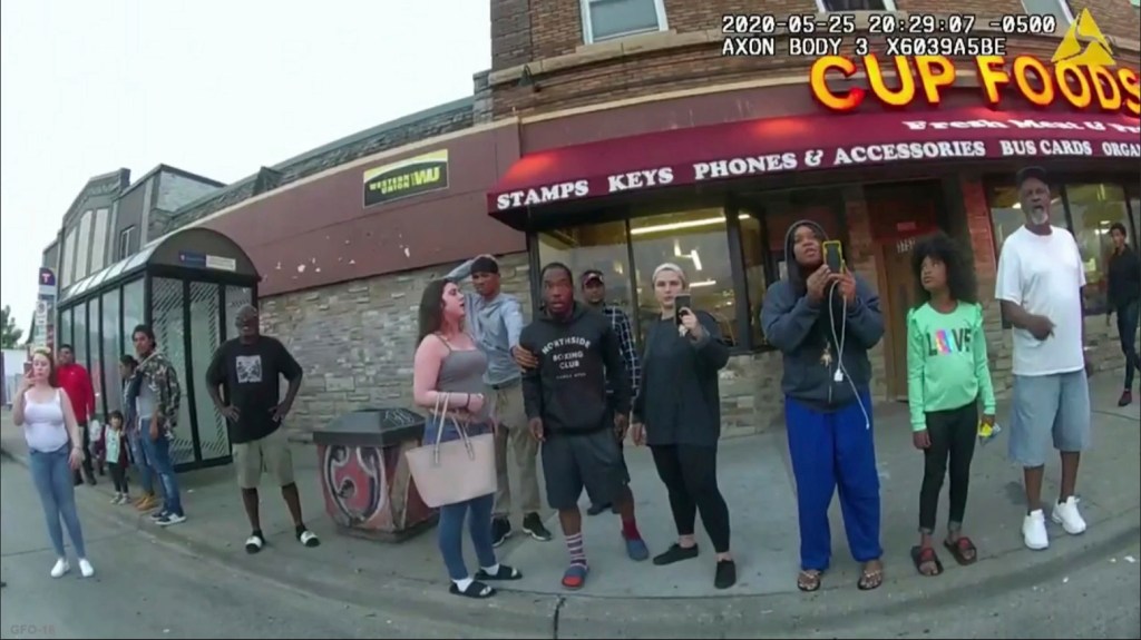 This May 25, 2020, file image from a police body camera shows bystanders including Darnella Frazier, third from right filming, as former Minneapolis police officer Derek Chauvin was recorded pressing his knee on George Floyd's neck for several minutes in