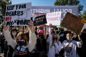 Protesters hold signs during a demonstration in Washington, D.C. on October 17, 2020.