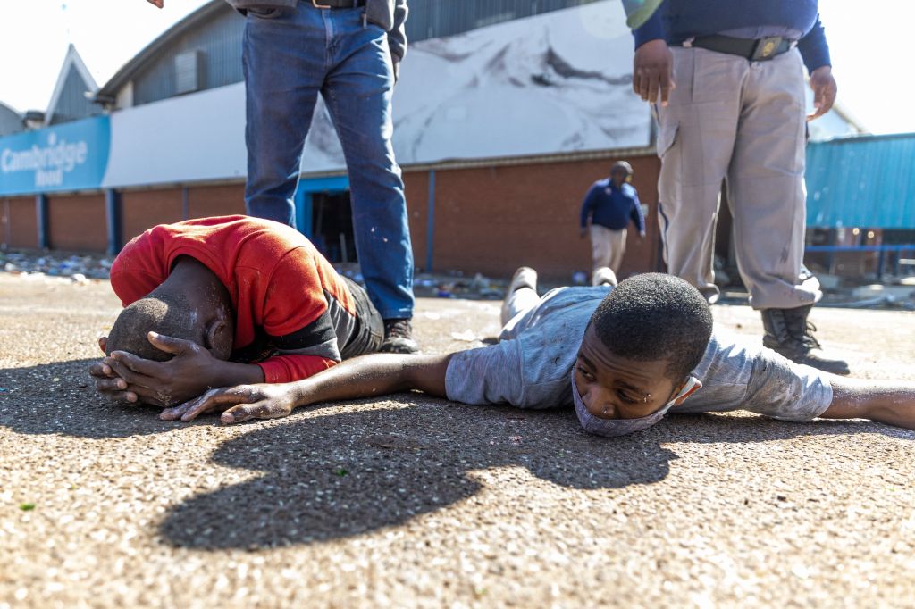 Two men lay on the ground after being arrested in Johannesburg. ​