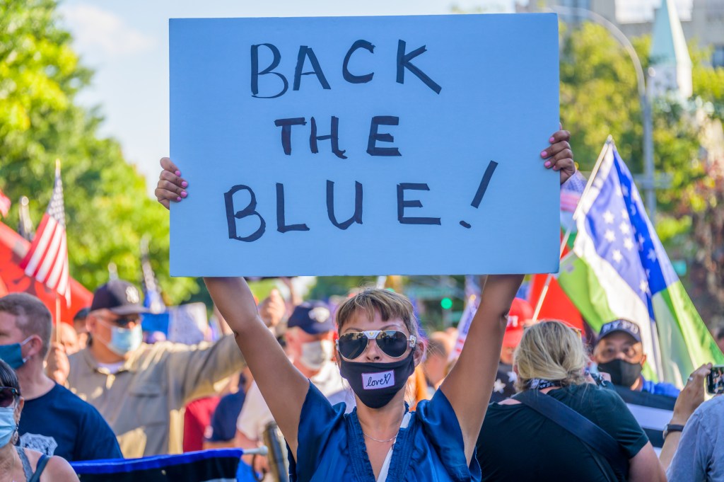 A participant holding a pro-police Back The Blue sign at a Black Lives Matter protest in Brooklyn, New York.