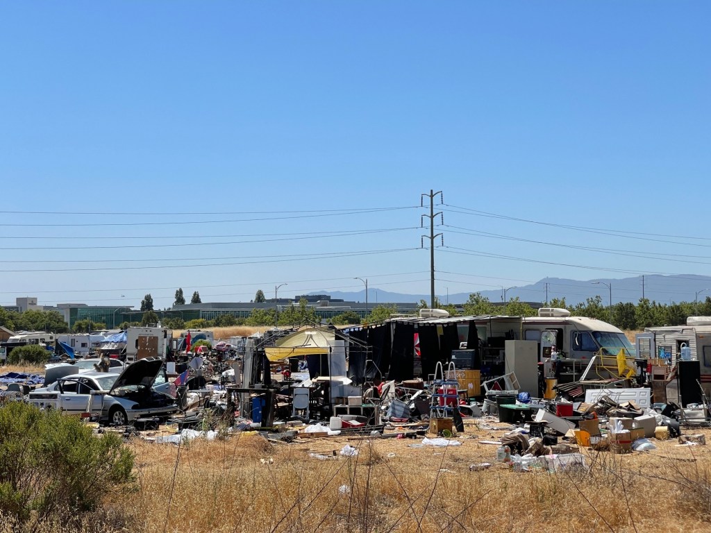 ​An RV and garbage strewn about one section of the homeless encampment on Apple's undeveloped property in San Jose, California.