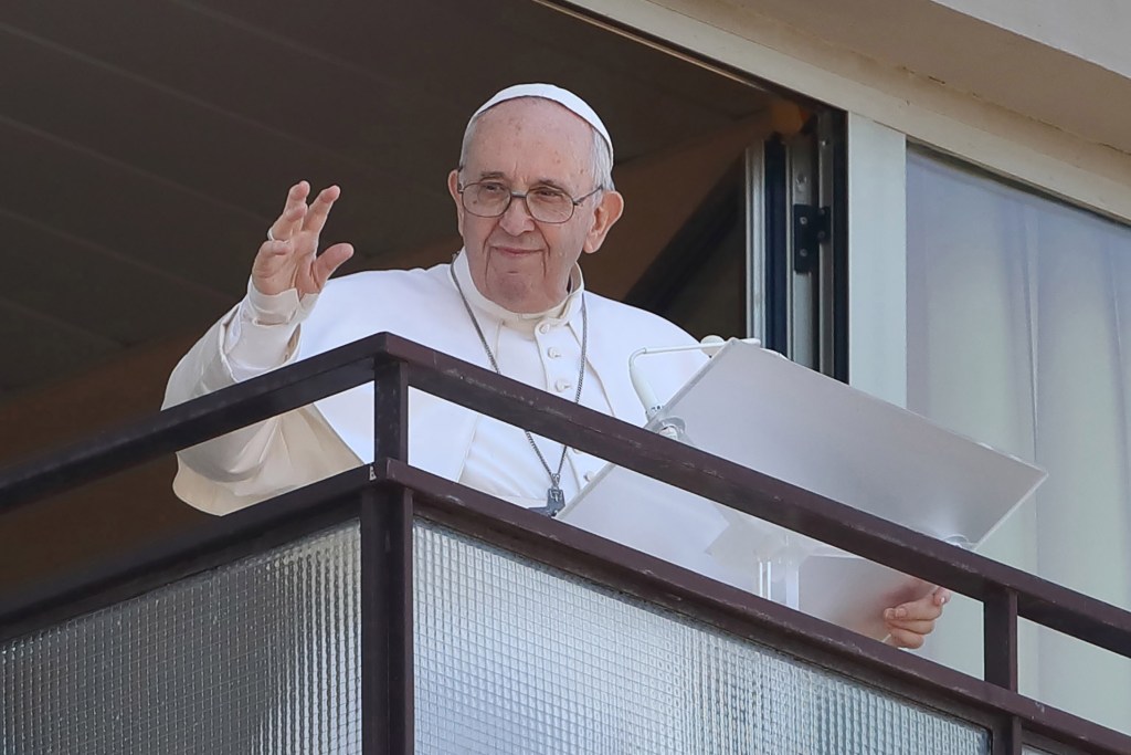 Pope Francis leading a prayer from a balcony