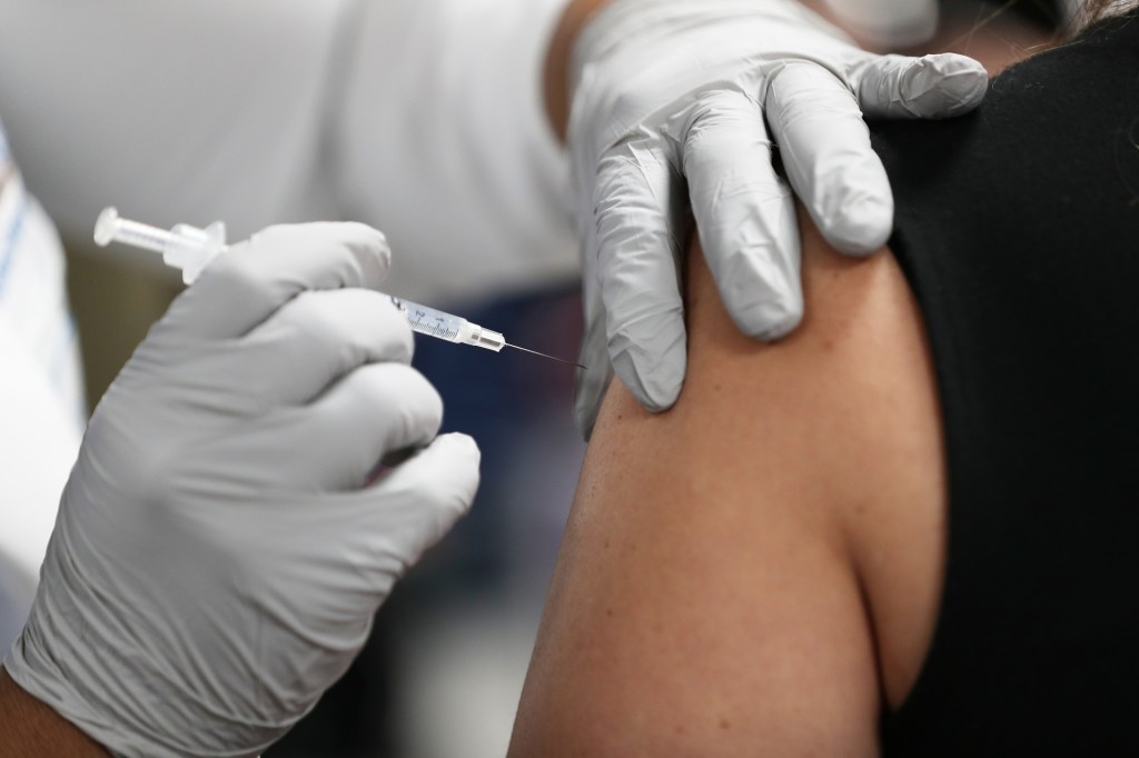 A healthcare worker at the Jackson Health Systems receives a Pfizer-BioNtech Covid-19 vaccine from Susana Flores Villamil, RN from Jackson Health Systems, at the Jackson Memorial Hospital on December 15, 2020 in Miami, Florida. (Joe Raedle/Getty Images)​