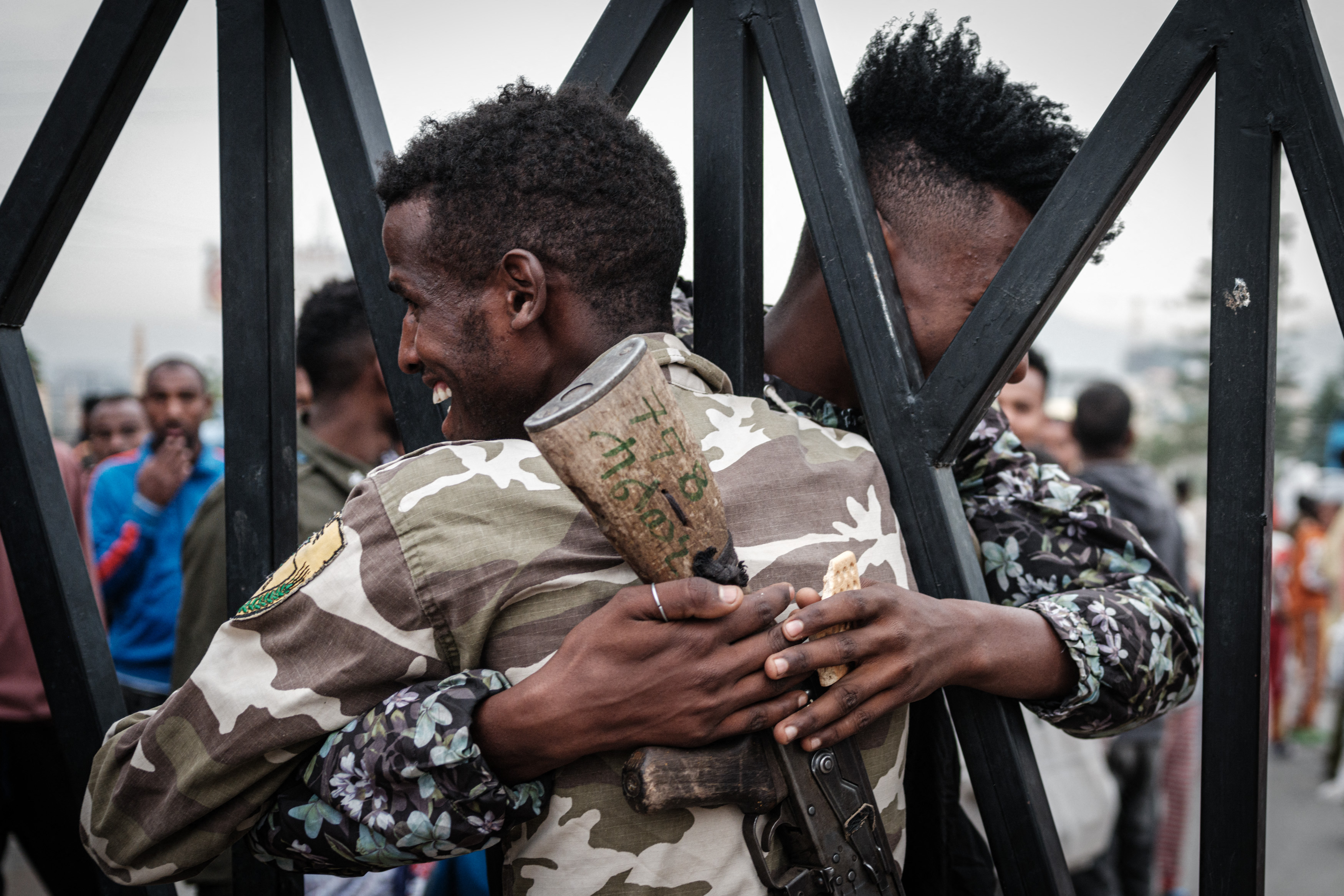 A soldier of Tigray Defence Force (TDF) greets his brother through the fence as they return at Tigray Martyr's Memorial Monument Center in Mekele