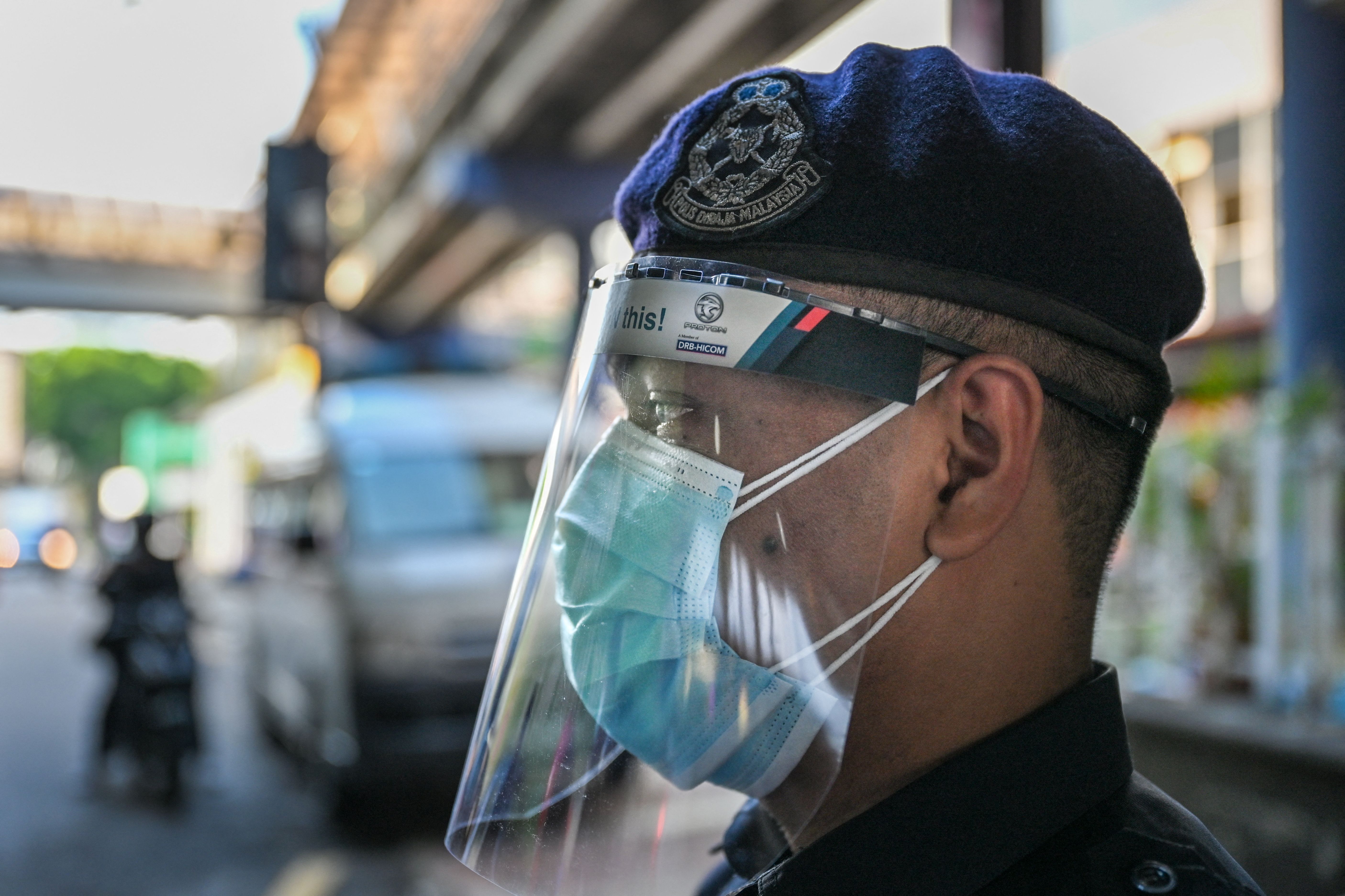 A policeman looks on at a roadblock during the nationwide lockdown in Malaysia. Photo: MOHD RASFAN/AFP via Getty Images