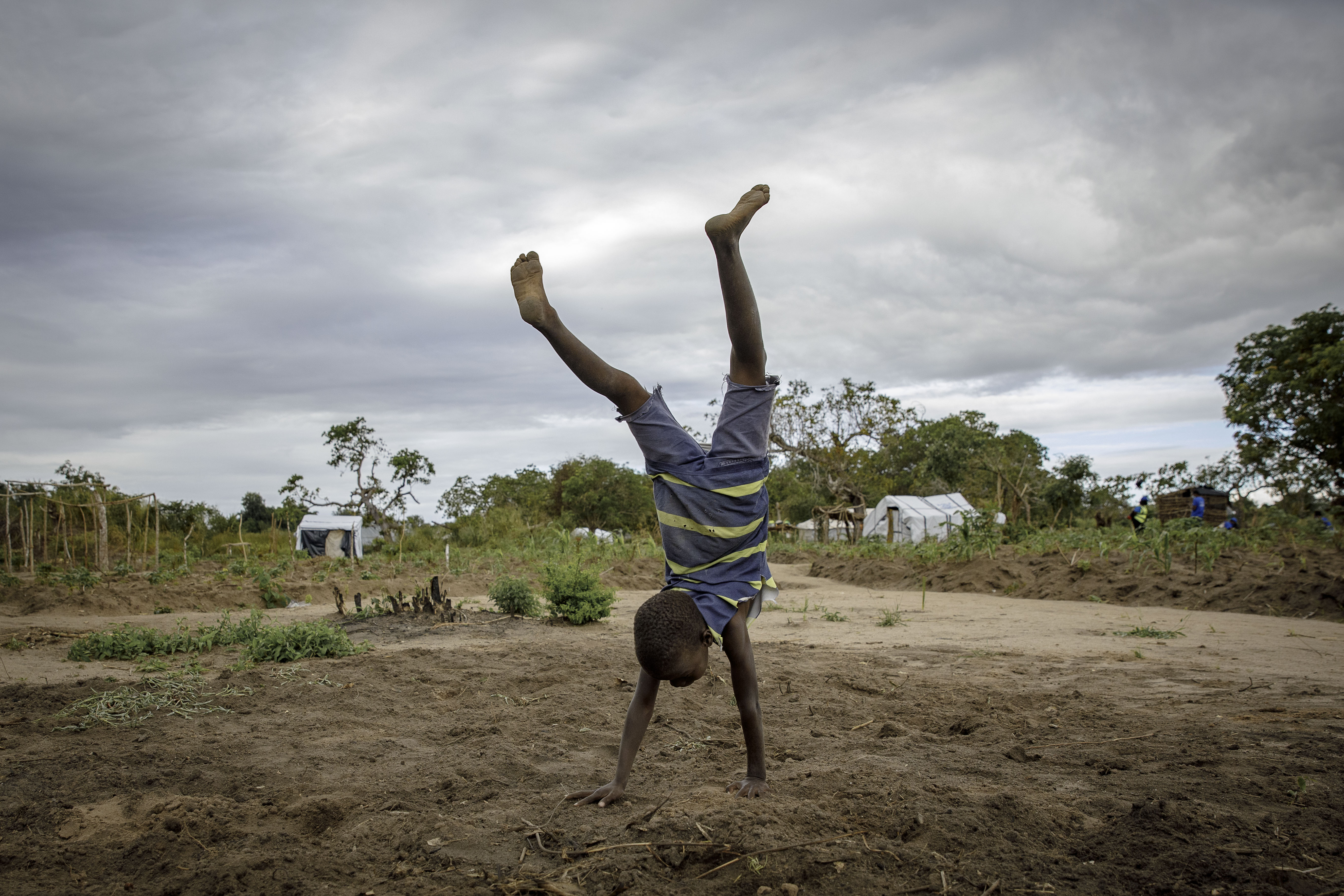 A boy walks on his hands in Mutua resettlement camp, Sofala province, central Mozambique.