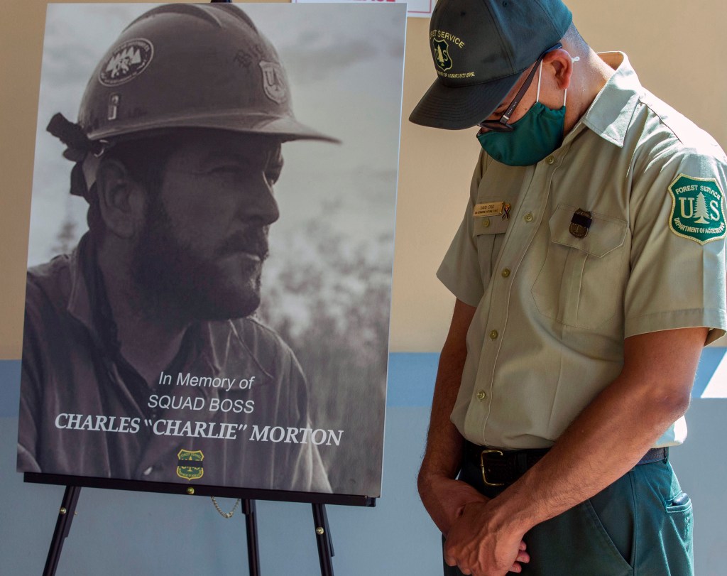 San Bernardino National Forest firefighter David Cruz lowers his head during a memorial for Charles Morton, the U.S. Forest Service firefighter assigned to the Big Bear Hotshots who was killed in the line of duty on Sept. 17 on the El Dorado Fire, Friday,