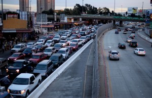 Motorists wait in line at the US-Mexico border to enter the United States, left, while cars head into Mexico, right in Tijuana. Cars crossing into Mexico from the US are a source of profit for the cartels.