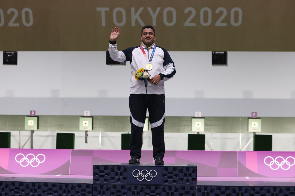 Gold Medalist Javad Foroughi of Team Iran poses on the podium following the 10m Air Pistol Men's event on day one of the Tokyo 2020 Olympic Games.