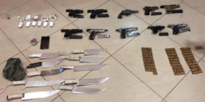 Officials found 10 handguns, 10 large knives, nearly 300 bullets and two makeshift grenades.