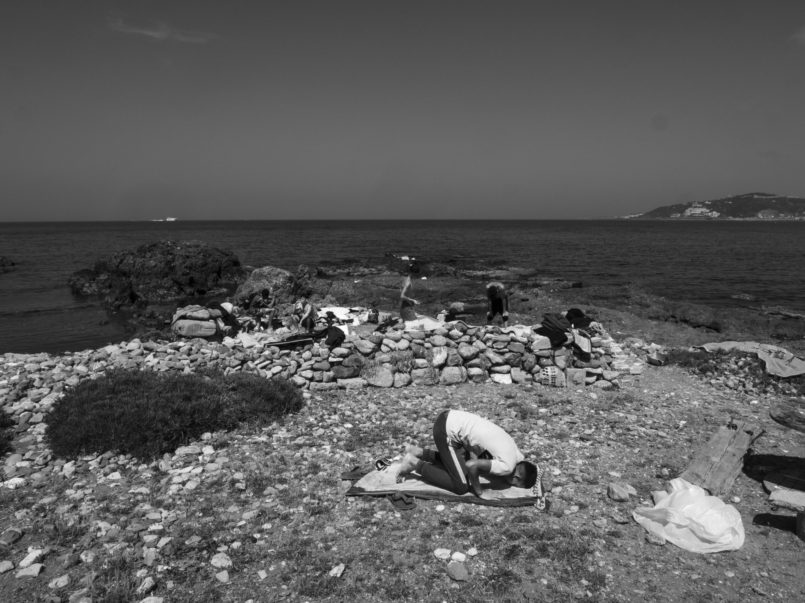 Hervé Lequeux, Ceuta – Un migrante prega su una spiaggia di Ceuta