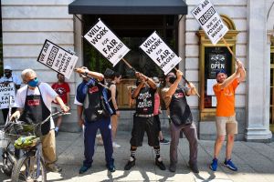 Activists take part in a protest outside of the Old Ebbitt Grill to call for a full minimum wage with tips for restaurant workers in Washington, DC.