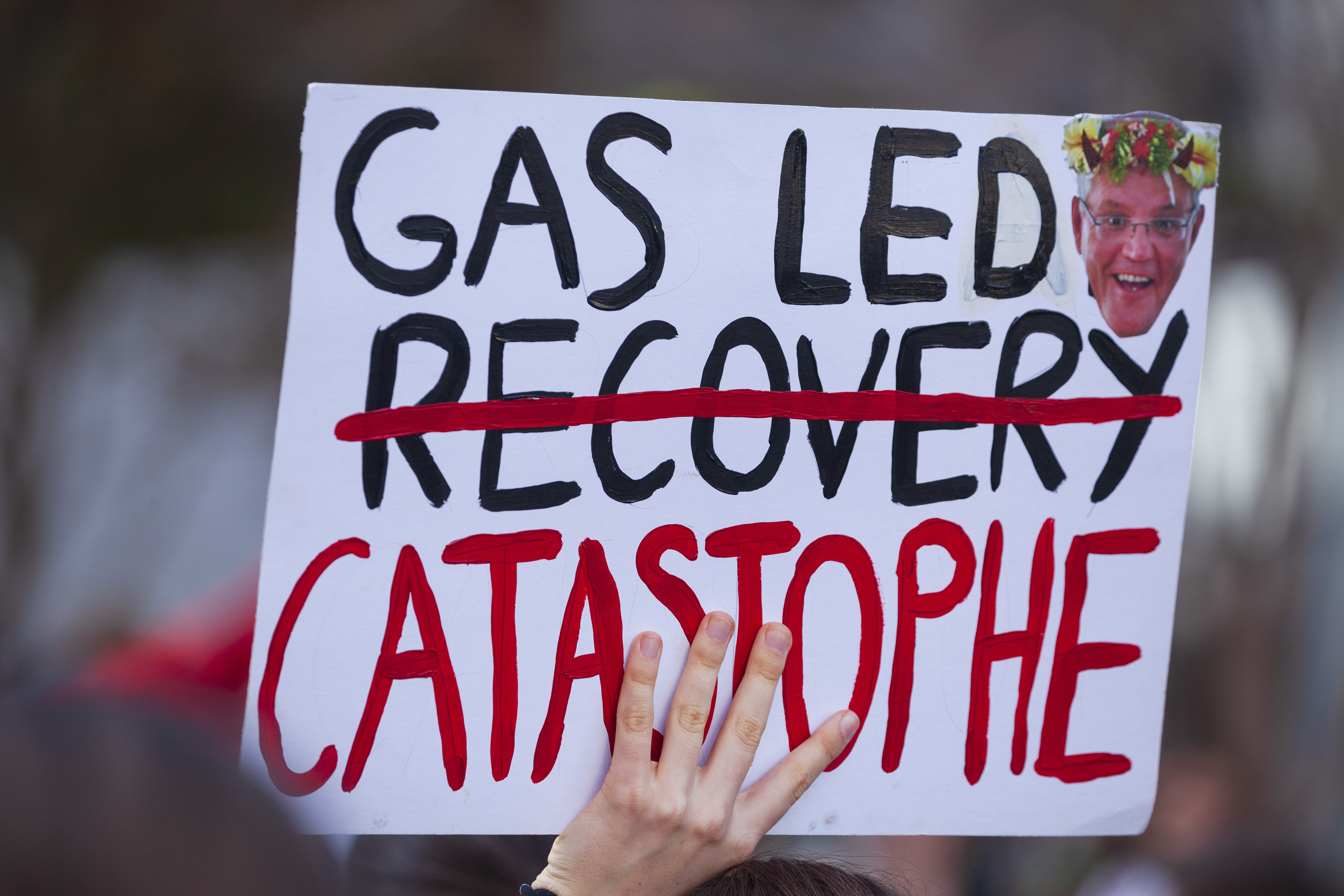 A protester holds a placard during the demonstration in Brisbane. Photo: Joshua Prieto/SOPA Images/LightRocket via Getty Images