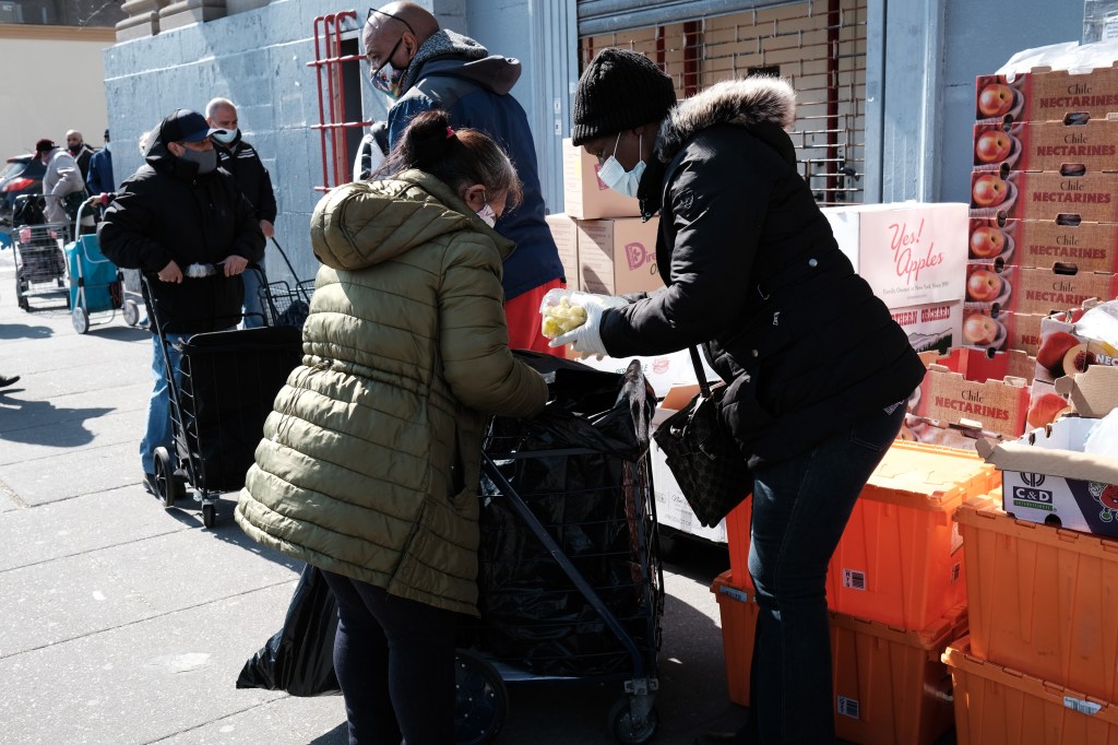 People wait in line at a food distribution outside of a church in the South Bronx on March 10, 2021 in New York City. People across the U.S. have needed unemployment benefits while the coronavirus pandemic has impacted businesses and caused job loss.